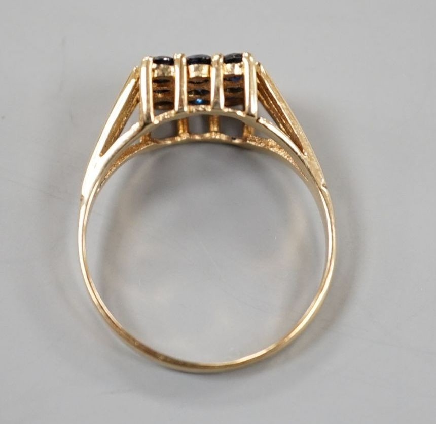 A modern 9ct gold and nine stone sapphire set tablet ring, size R/S, gross weight 2.7 grams.